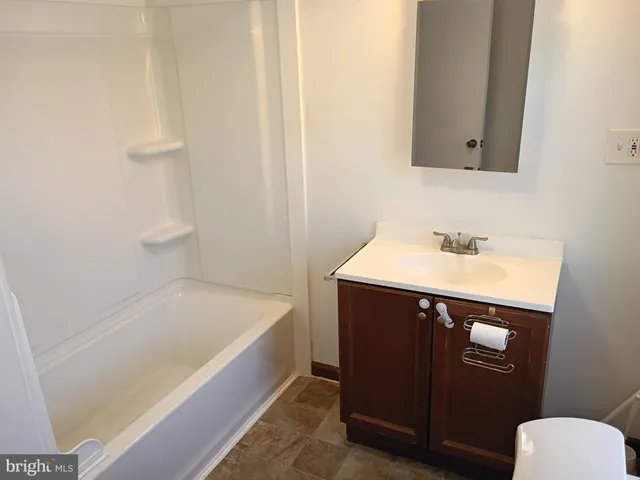 a bathroom with a sink a toilet a mirror and shower