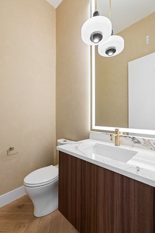 a bathroom with a granite countertop sink a toilet and a mirror