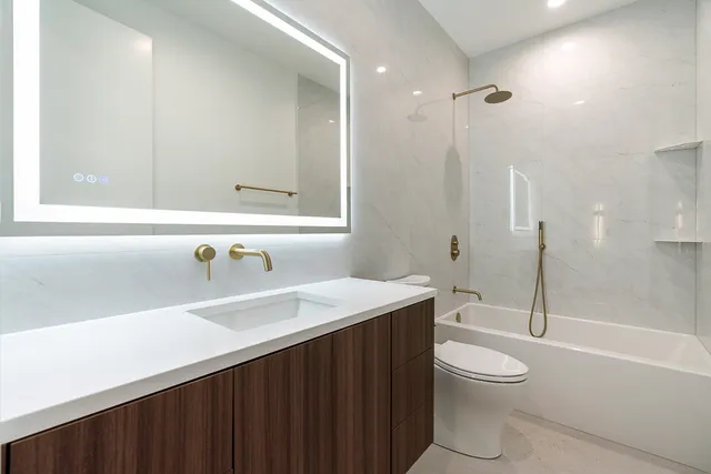 a bathroom with a sink a toilet and shower