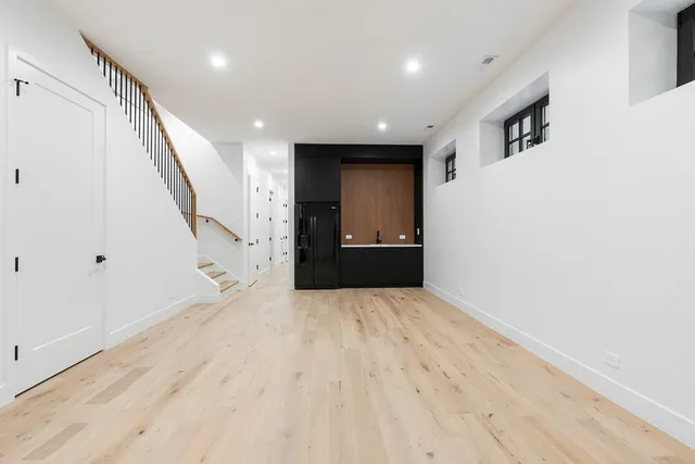 a view of an empty room with wooden floor and stairs