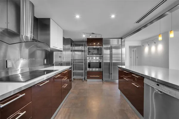 a large kitchen with stainless steel appliances and a counter top