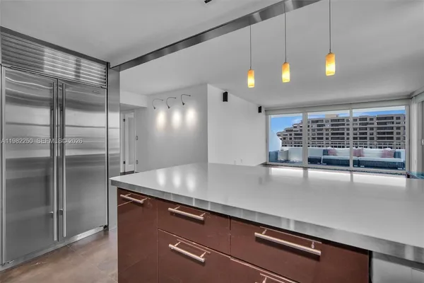 a kitchen with kitchen island a counter space a sink appliances and cabinets