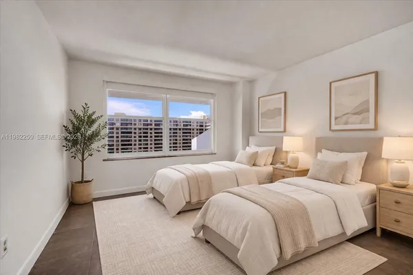 a bed room with two beds and a potted plant