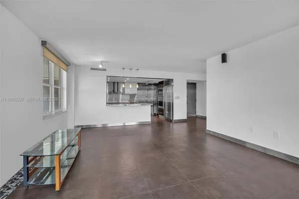 a view of empty room with wooden floor and windows