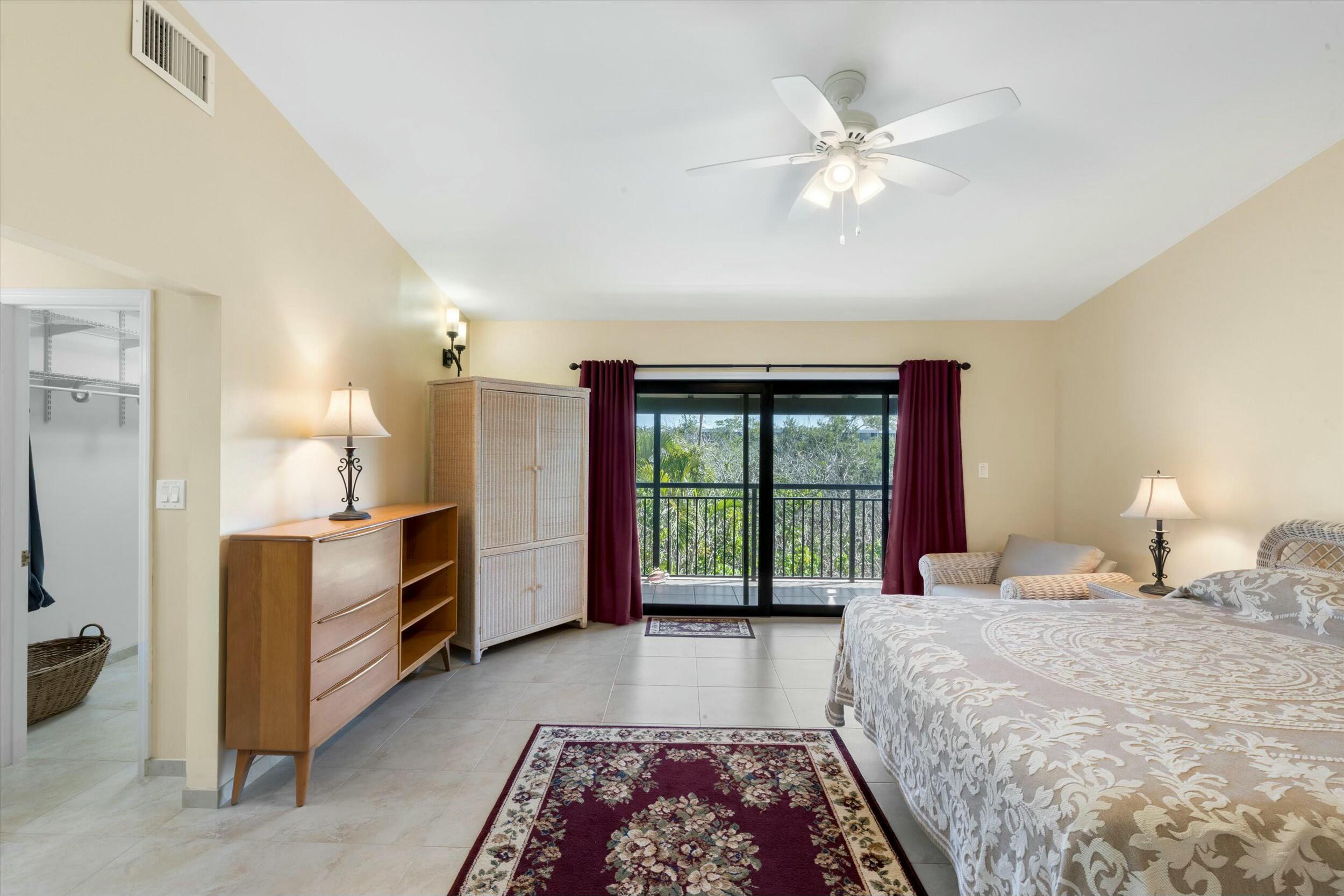 1616 Atlantic Boulevard, Unit 13 Key West, FL 33040 - Photo 13 of 38 a bedroom with a large bed and a chandelier