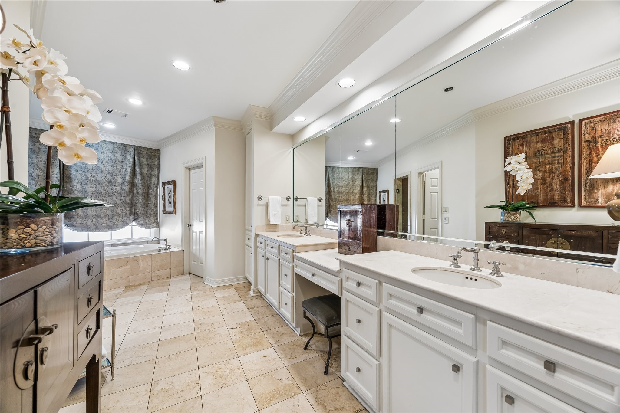 2627 Sutton Court Houston, TX 77027 - Photo 18 of 34 The ensuite bath features ceramic tile, dual sinks, a vanity and expansive countertop, making getting ready effortless and convenient.