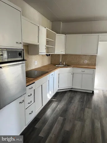a kitchen with granite countertop white cabinets and white appliances