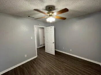 a view of an empty room with wooden floor