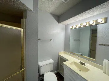 a bathroom with a granite countertop sink toilet and shower