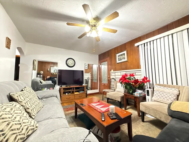 a living room with furniture a chandelier and a flat screen tv