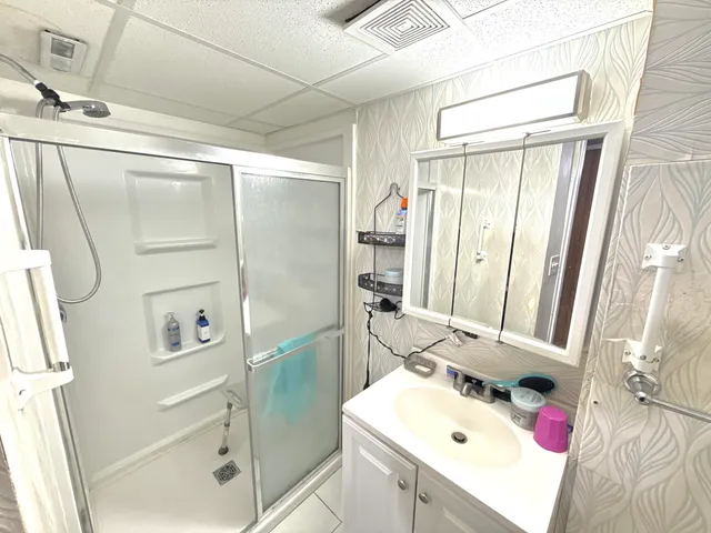 a bathroom with a sink mirror and shower