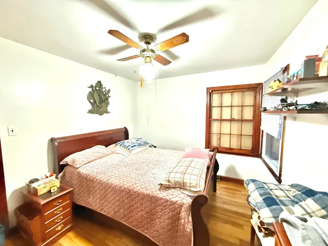 a bedroom with a bed and wooden floor