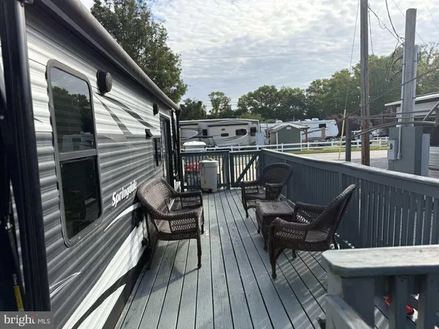 a view of a balcony with chairs and wooden floor