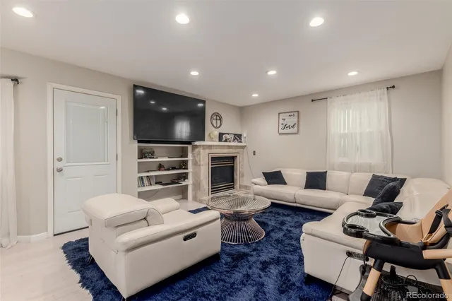 a living room with furniture a flat screen tv and a fireplace