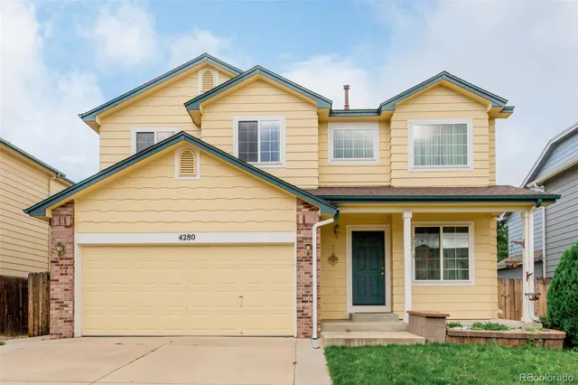 a view of a house with a small yard and wooden fence
