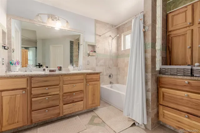 a bathroom with a granite countertop sink a mirror a vanity and a bathtub