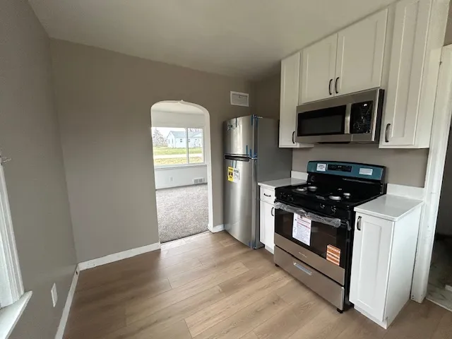 a kitchen with stainless steel appliances granite countertop a stove a microwave and a refrigerator