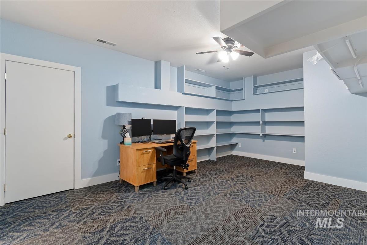 10462 West Lanktree Gulch Road Star, ID 83669 - Photo 34 of 48 Room featuring extensive built-in shelving, patterned carpet flooring, a ceiling fan with integrated lighting, and light blue wall tones