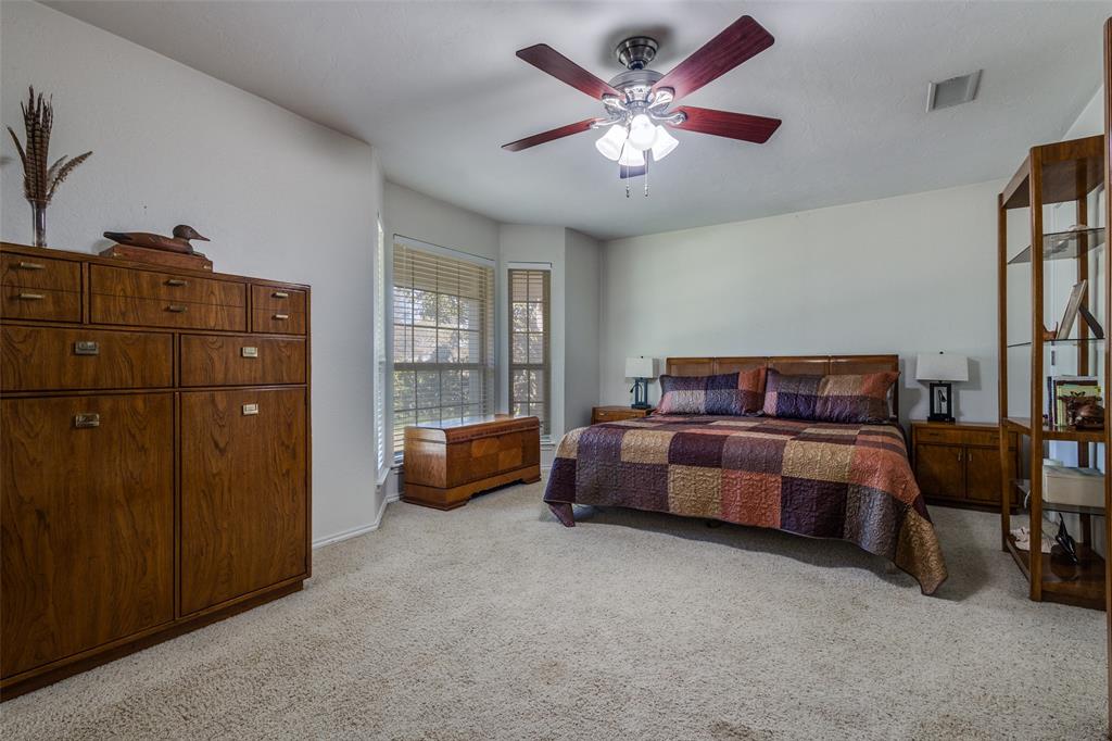 10 Biltmore Court Trophy Club, TX 76262 - Photo 17 of 25 a spacious bedroom with a bed and a chandelier