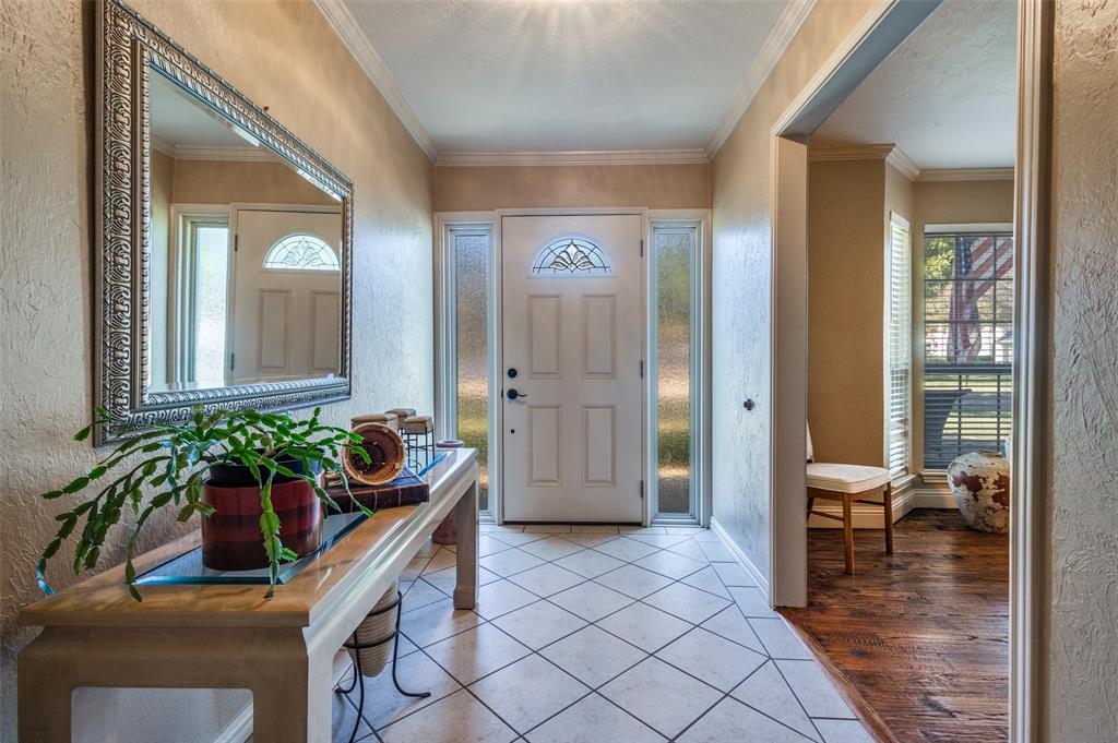 10 Biltmore Court Trophy Club, TX 76262 - Photo 3 of 25 a hallway with dining area and chandelier