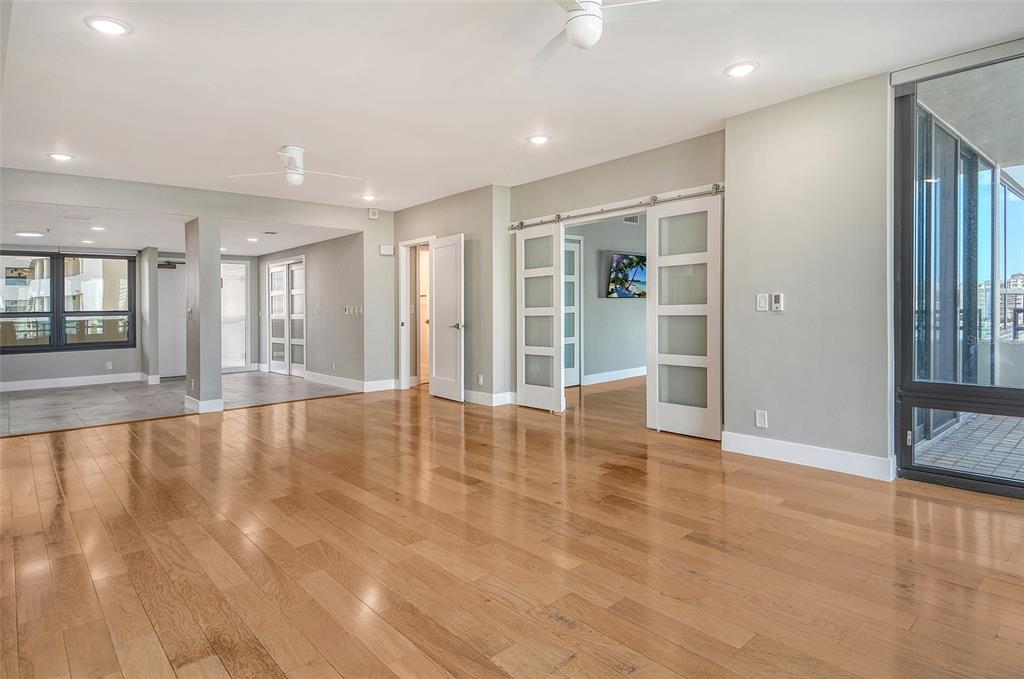 1255 North Gulfstream Avenue, Unit 702 Sarasota, FL 34236 - Photo 14 of 53 a view of an empty room with window and wooden floor