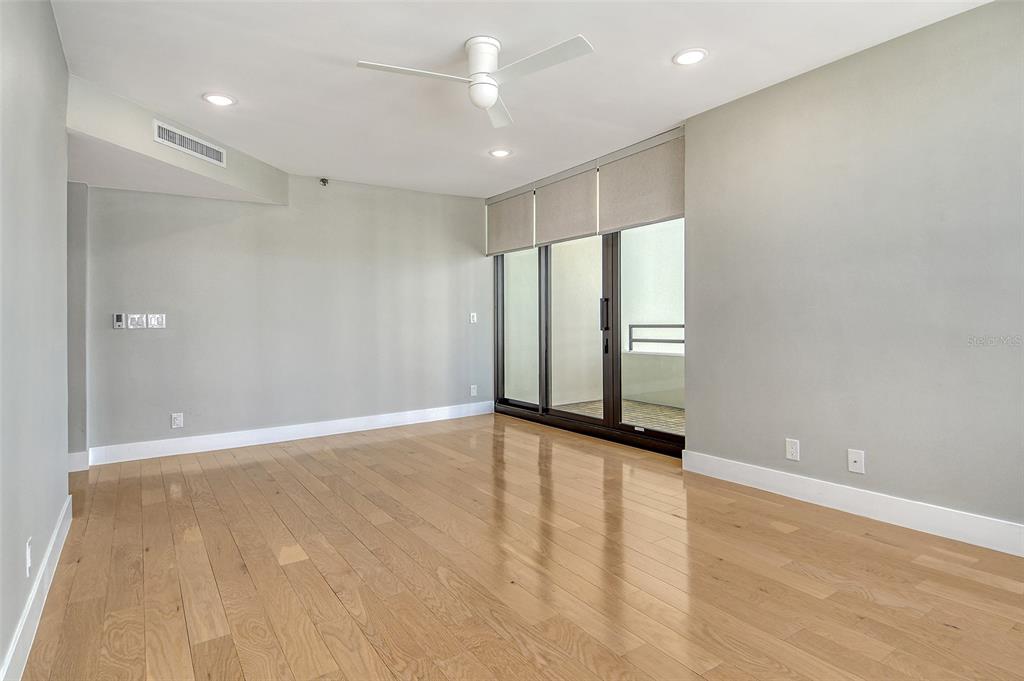 1255 North Gulfstream Avenue, Unit 702 Sarasota, FL 34236 - Photo 23 of 53 an empty room with wooden floor and windows