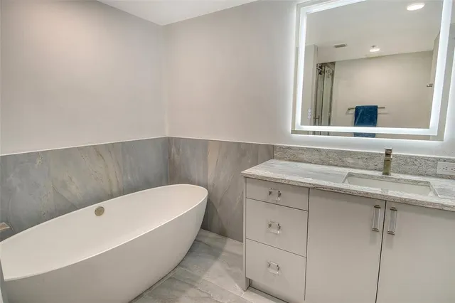a bathroom with a granite countertop sink mirror and a