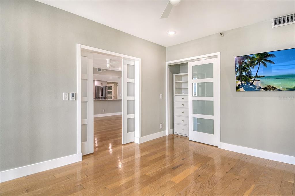 1255 North Gulfstream Avenue, Unit 702 Sarasota, FL 34236 - Photo 32 of 53 an empty room with wooden floor and windows