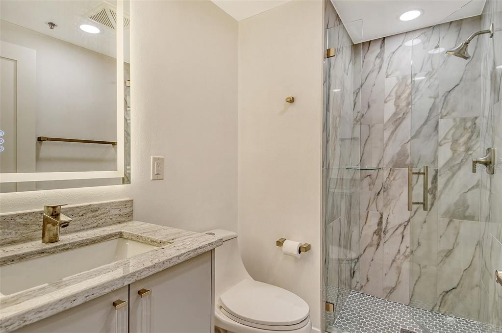 1255 North Gulfstream Avenue, Unit 702 Sarasota, FL 34236 - Photo 33 of 53 a bathroom with a granite countertop sink toilet and shower
