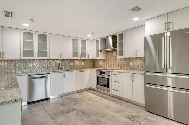 a kitchen with a refrigerator sink and cabinets