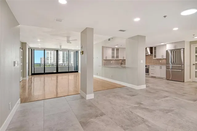 a view of a kitchen with refrigerator and wooden floor