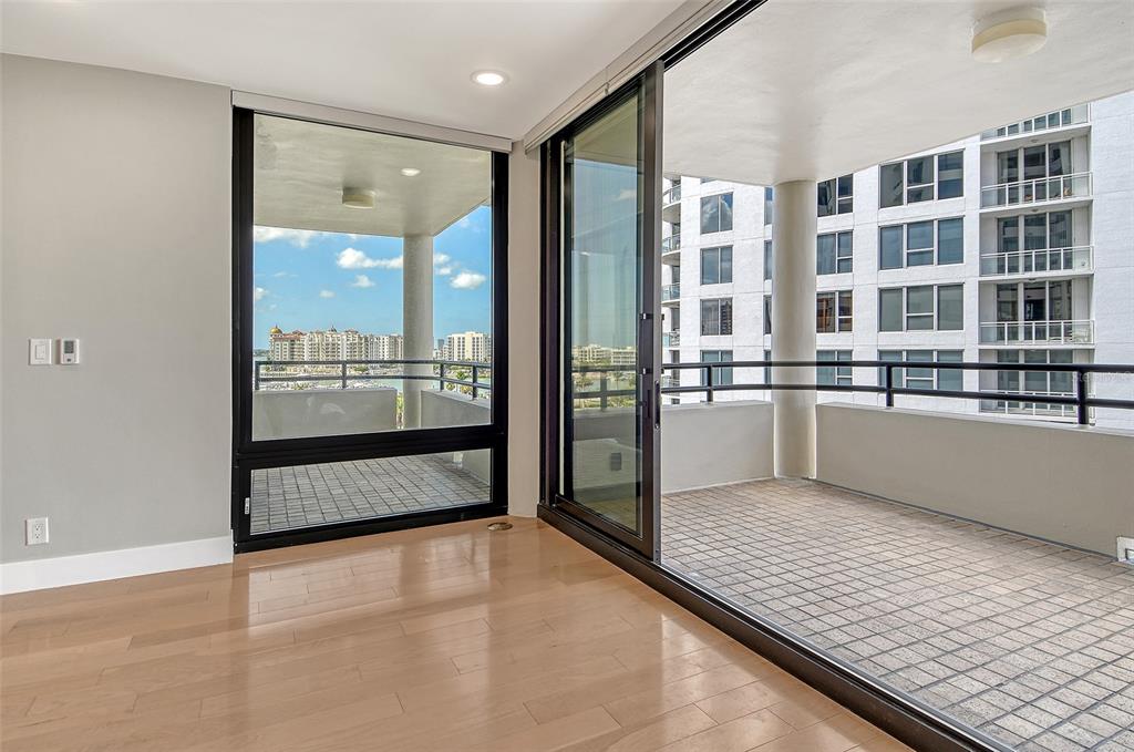 1255 North Gulfstream Avenue, Unit 702 Sarasota, FL 34236 - Photo 9 of 53 a view of an empty room with kitchen view and wooden floor