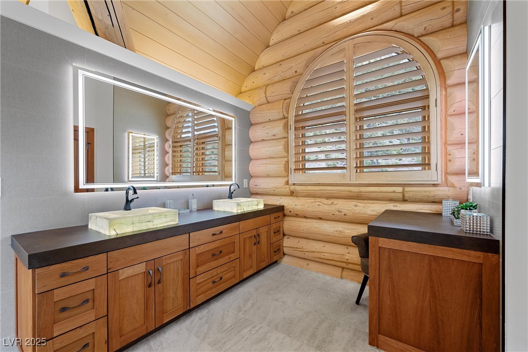 4927 Snow White Road Mount Charleston, NV 89124 - Photo 27 of 65 Bathroom featuring light up onyx sinks, porcelain counter tops, light up mirrors and a makeup table