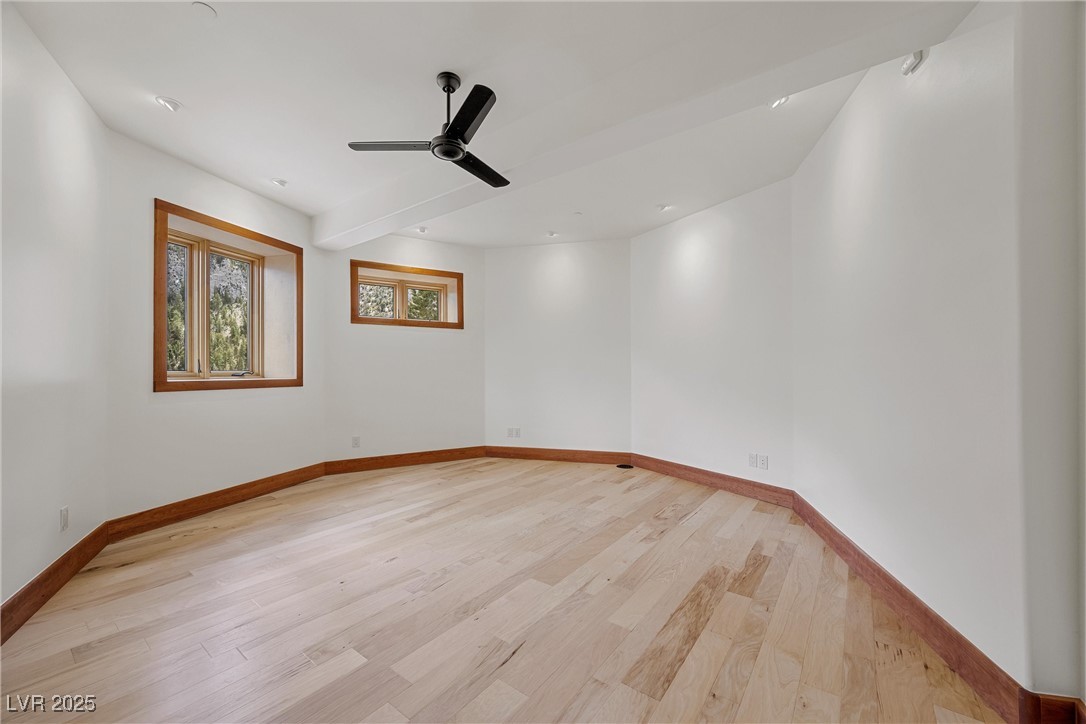 4927 Snow White Road Mount Charleston, NV 89124 - Photo 41 of 65 Downstairs bedroom with light wood-style floors, baseboards, and ceiling fan