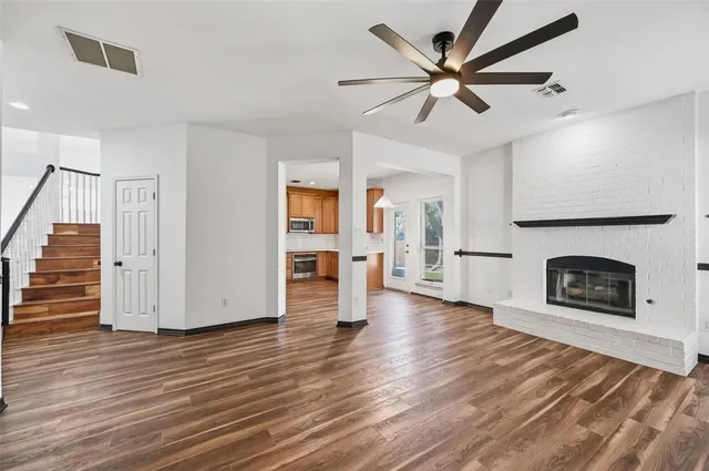 a view of a livingroom with wooden floor and a ceiling fan