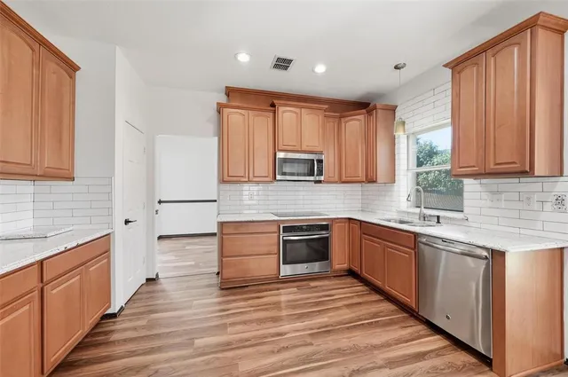 a kitchen with stainless steel appliances granite countertop a sink stove and refrigerator