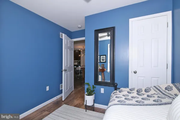 a bedroom with a bed and wooden floor