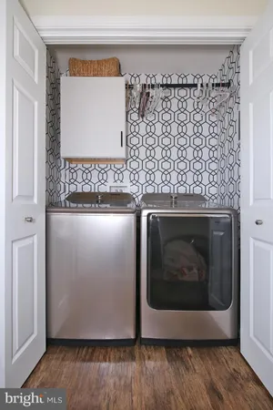a utility room with wooden floor washer and dryer