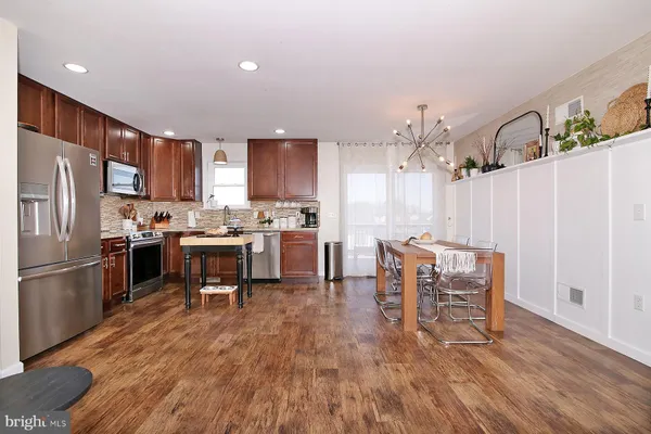 a kitchen with kitchen island granite countertop wooden floors and stainless steel appliances