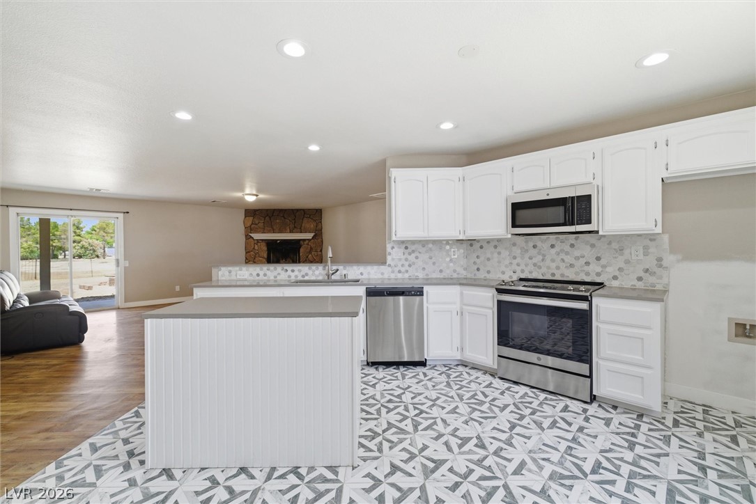 2780 West Simkins Road Pahrump, NV 89060 - Photo 18 of 40 A well-appointed kitchen features stainless steel appliances, a center island, and a mosaic tile backsplash.
