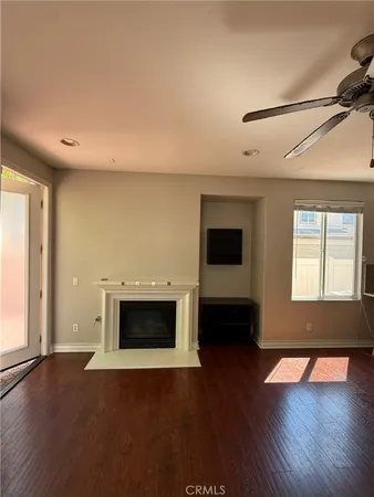 a living room with a flat screen tv and wooden floor
