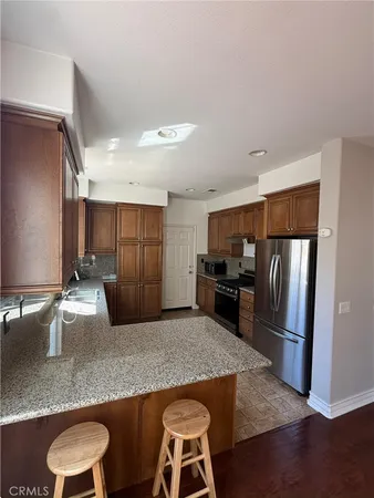 a kitchen with kitchen island a counter top space cabinets and stainless steel appliances