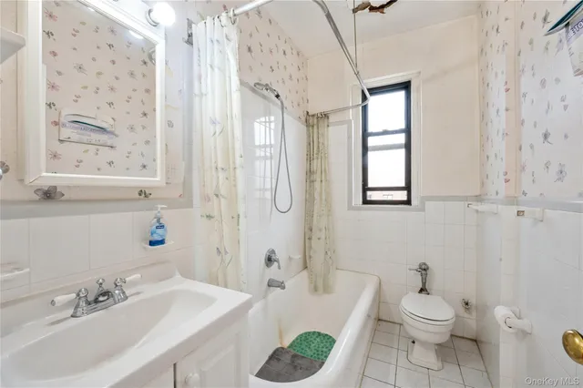 a bathroom with a sink a toilet and shower curtain