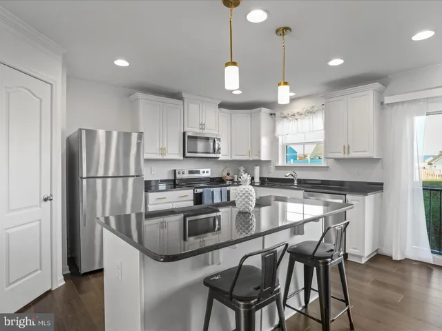 a kitchen with stainless steel appliances granite countertop a refrigerator a stove a sink dishwasher and a refrigerator with wooden floor