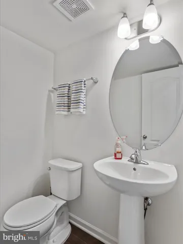 a bathroom with a toilet a sink and mirror