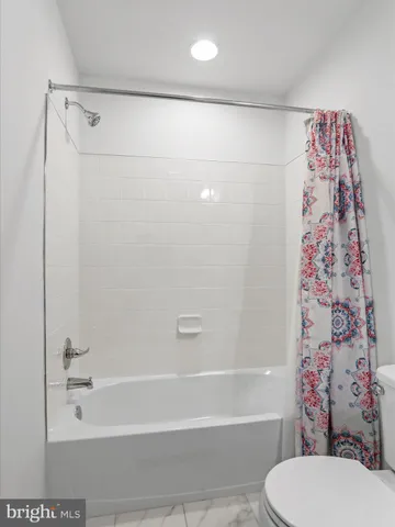 a bathroom with a toilet and a shower curtain
