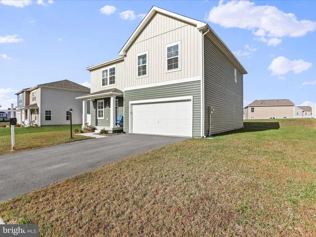 a view of a white house with a yard and garage