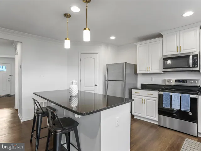 a kitchen with kitchen island a counter space a sink and stainless steel appliances