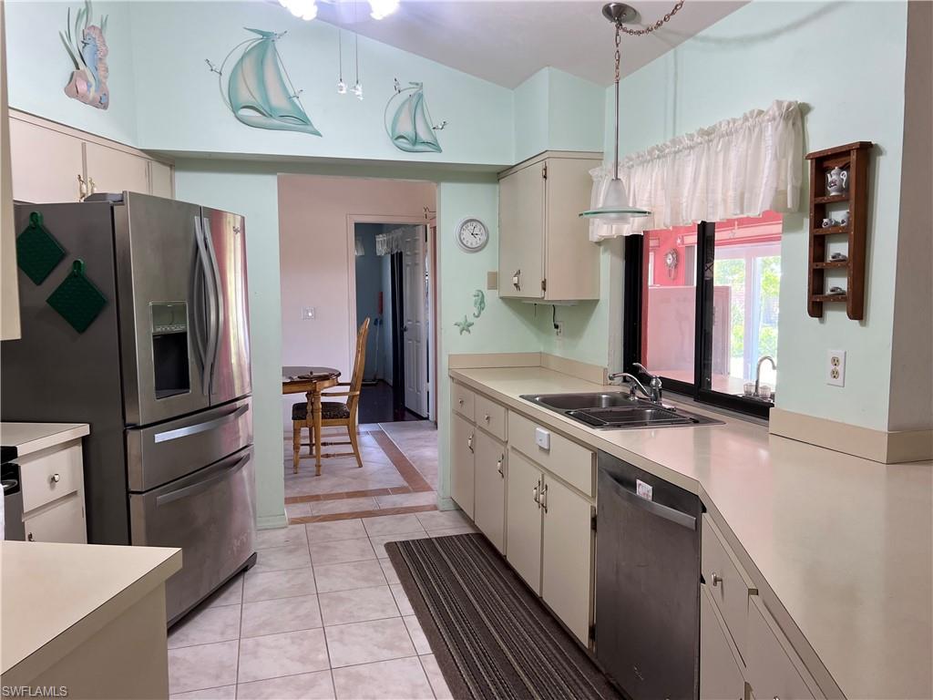 140 Bordeaux Circle Naples, FL 34112 - Photo 13 of 22 a kitchen with stainless steel appliances granite countertop a refrigerator a oven and white cabinets with wooden floors