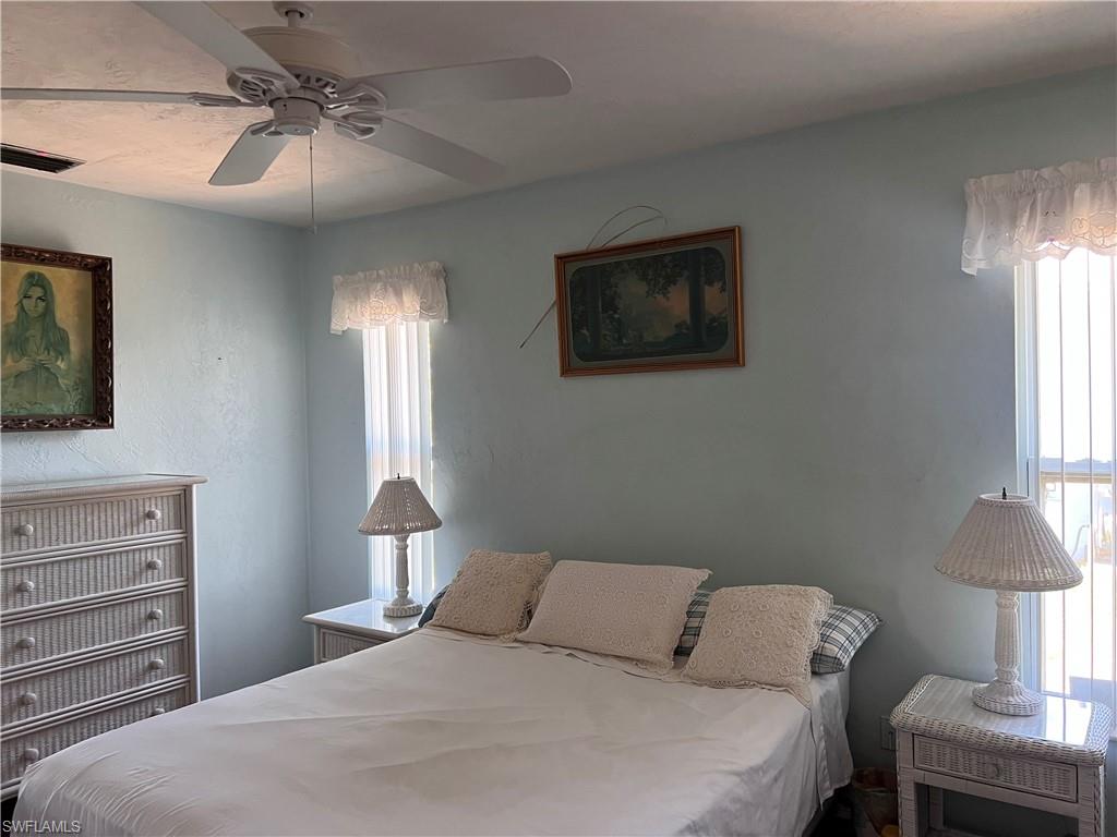 140 Bordeaux Circle Naples, FL 34112 - Photo 17 of 22 a bedroom with a bed and a lamp on dresser